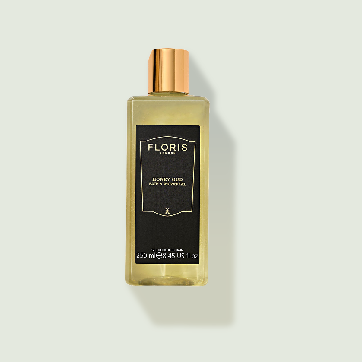 Floris Honey Oud dušas želeja uz salvijas krāsas fona