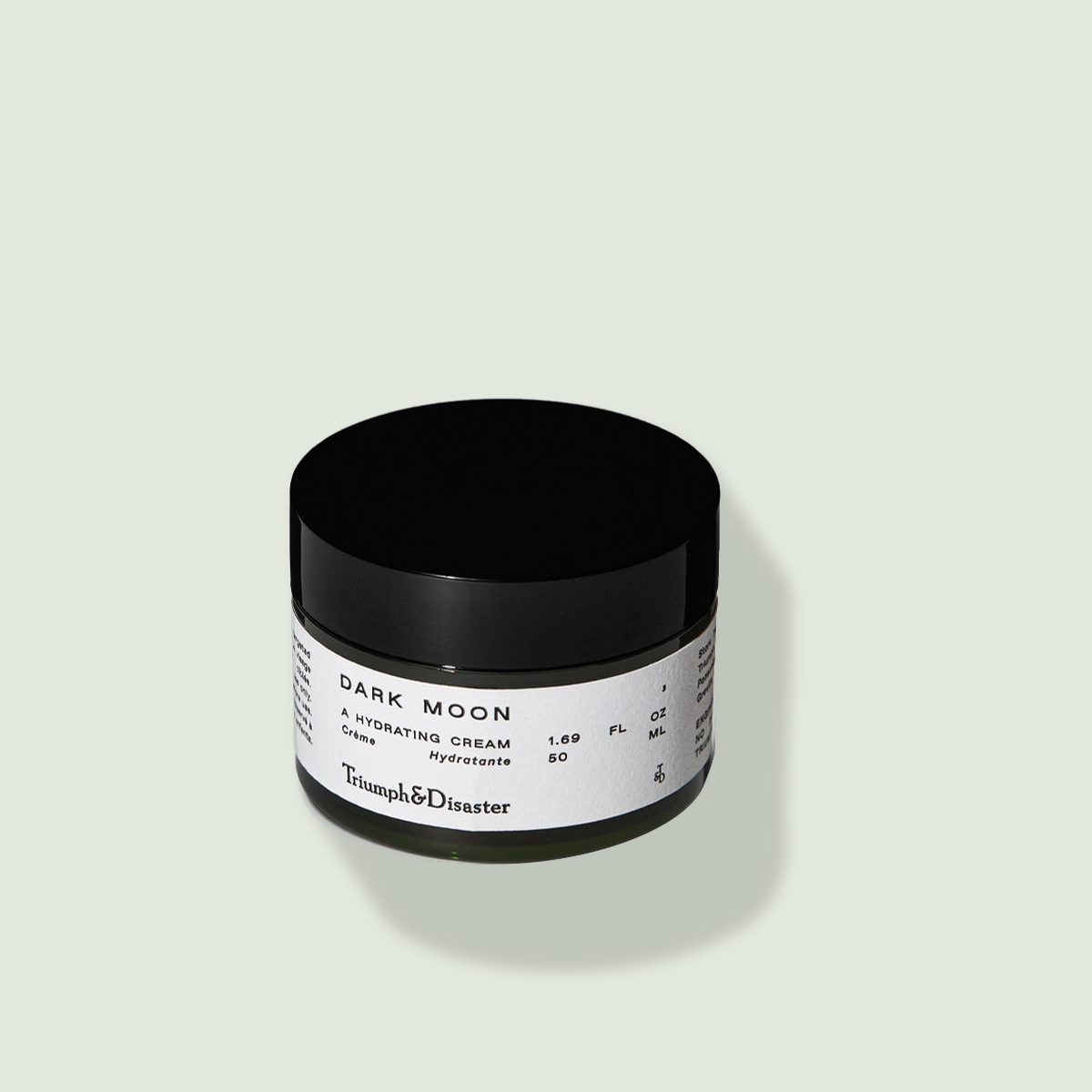 Triumph & Disaster Dark Moon Hydrating Cream uz salvijas krāsas fona